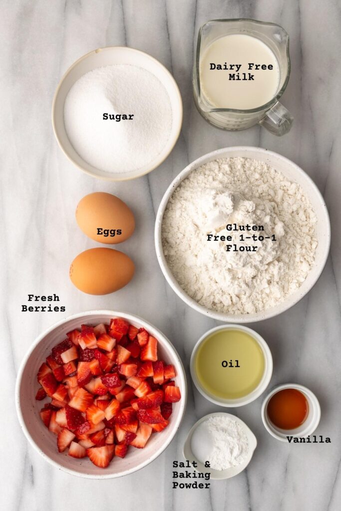 Ingredients for gluten free strawberry muffins on a white table.