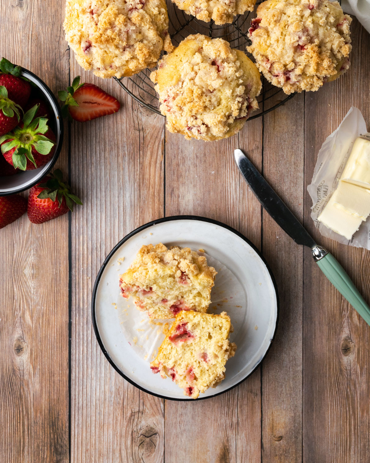 Gluten free strawberry muffins on a cooling rack sitting on a wooden table.