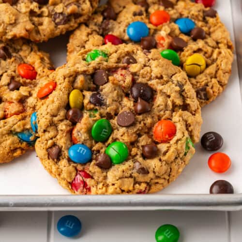 Gluten free monster cookies scattered on a baking sheet.