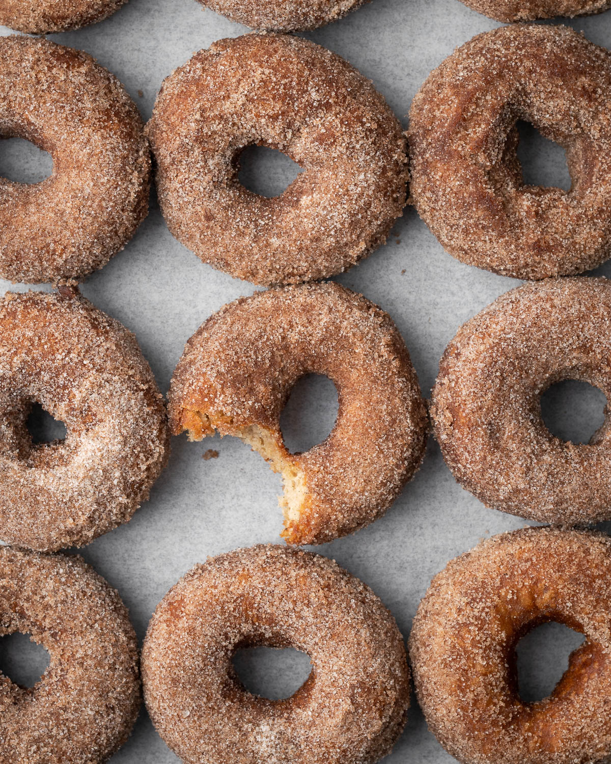 A gluten free apple cider donut with a bite taken out. 