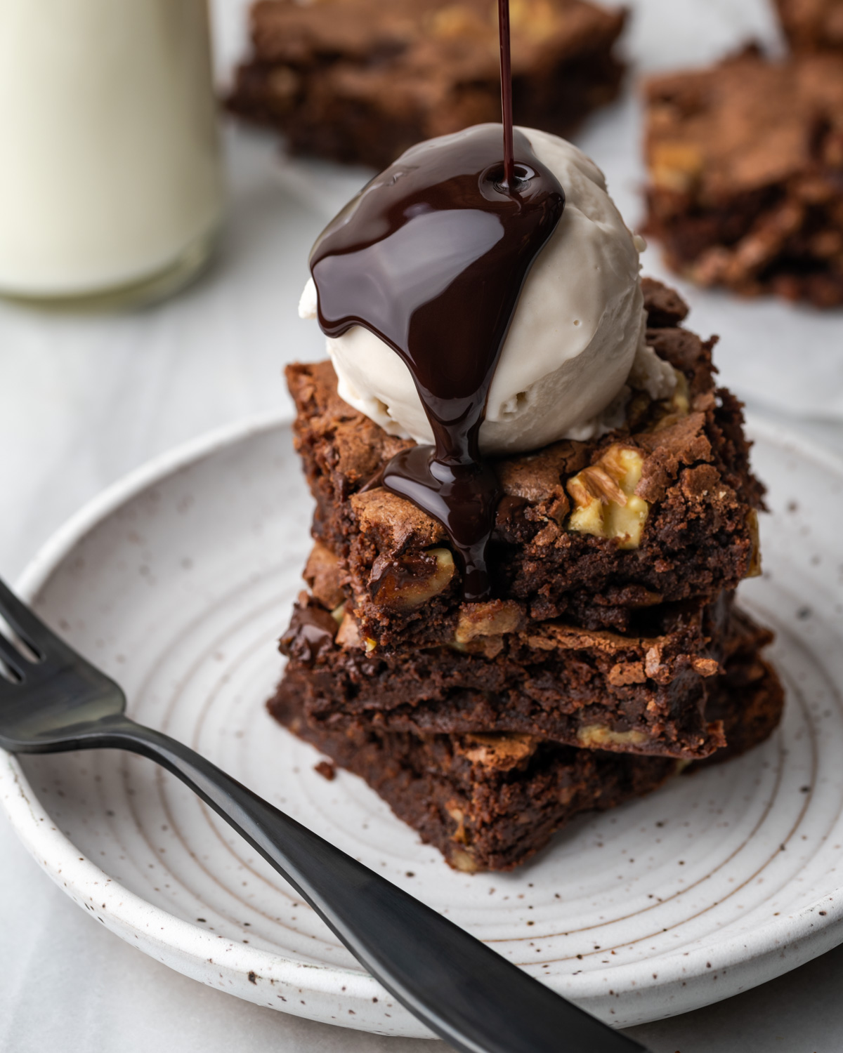 Hot fudge brownie sundae on a white plate.