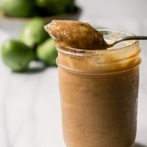 A jar of paw paw butter on a white table.