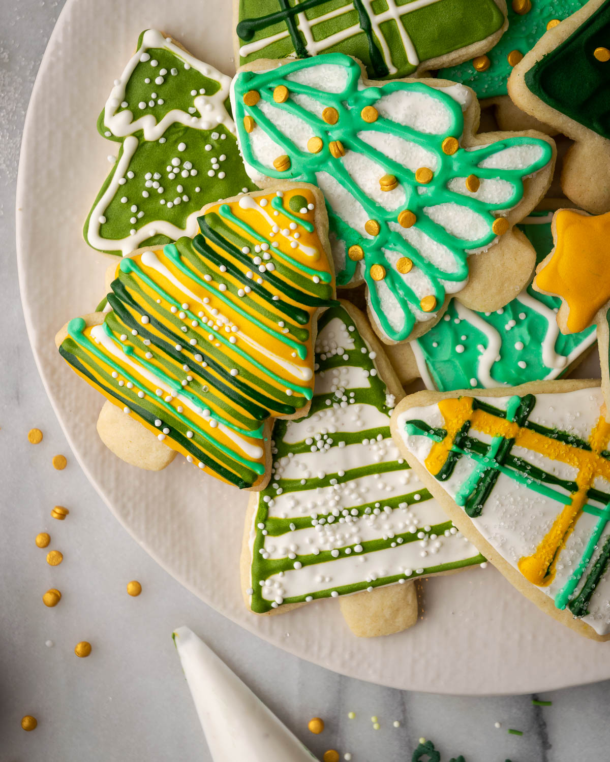 Christmas tree cut out sugar cookies on a white plate.