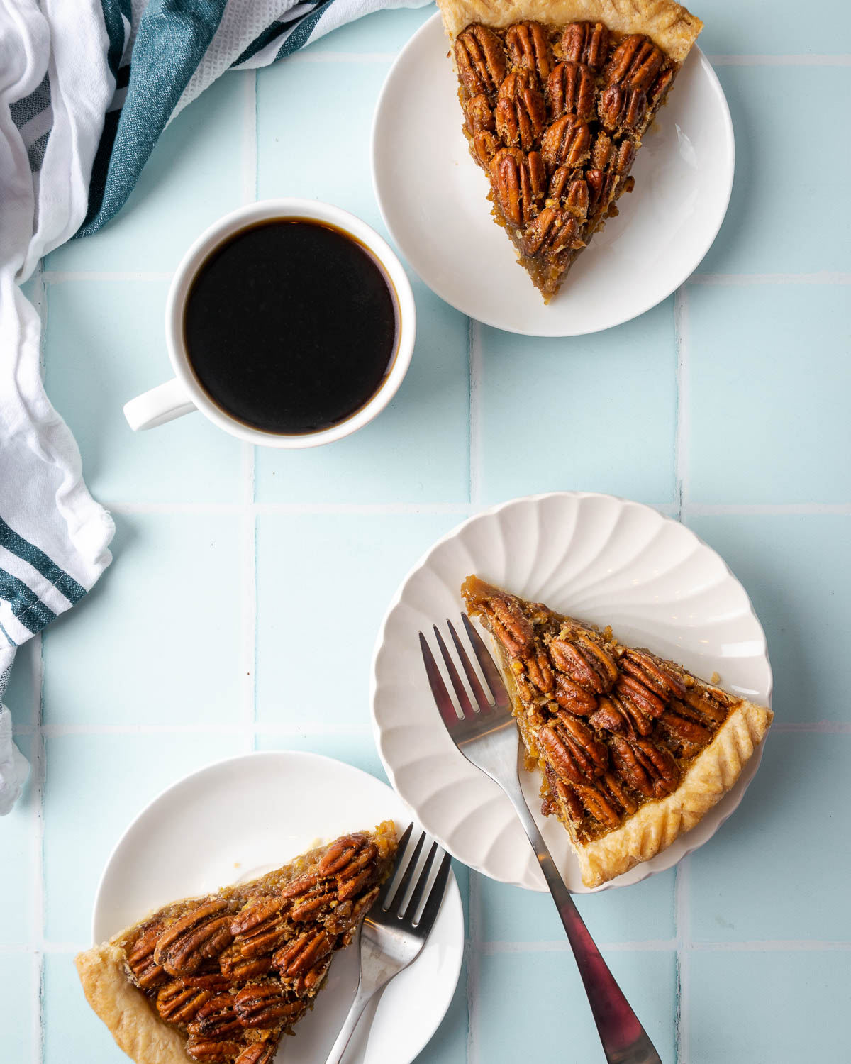 Three slices of pecan pie on white plates.