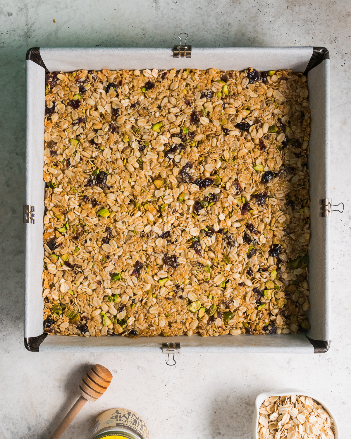 A freshly baked pan of gluten free granola bars on a white table.