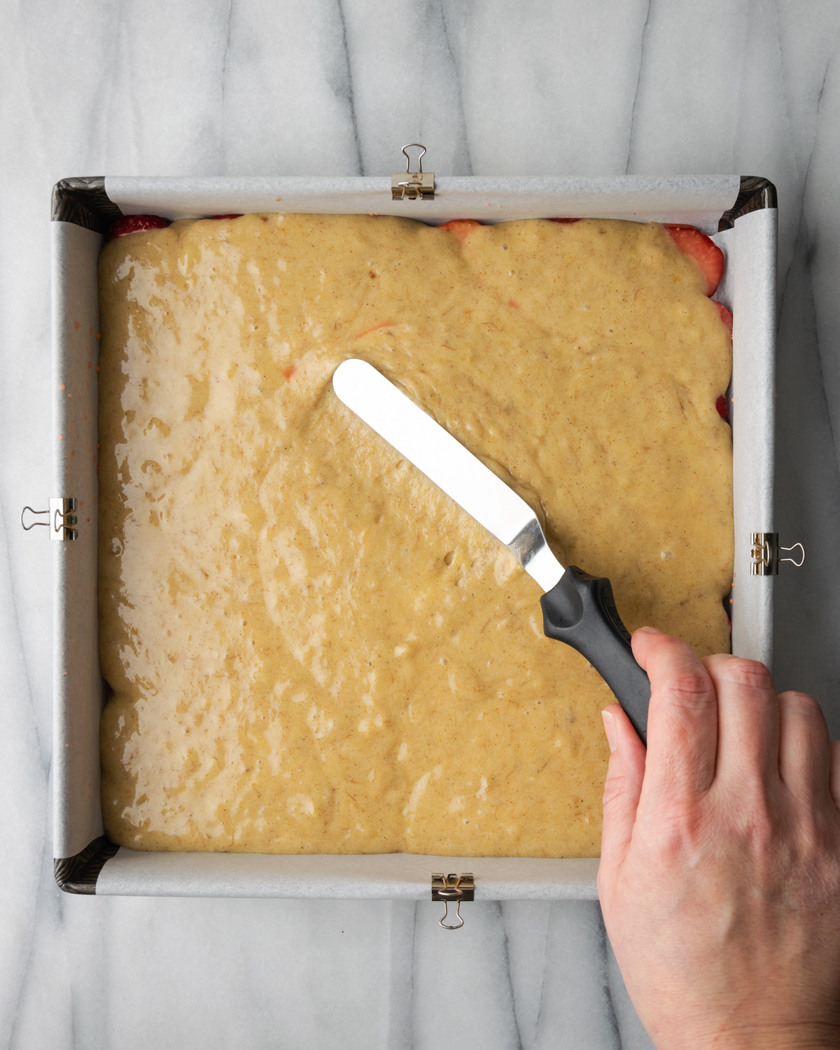 Spreading batter with an offset spatula.
