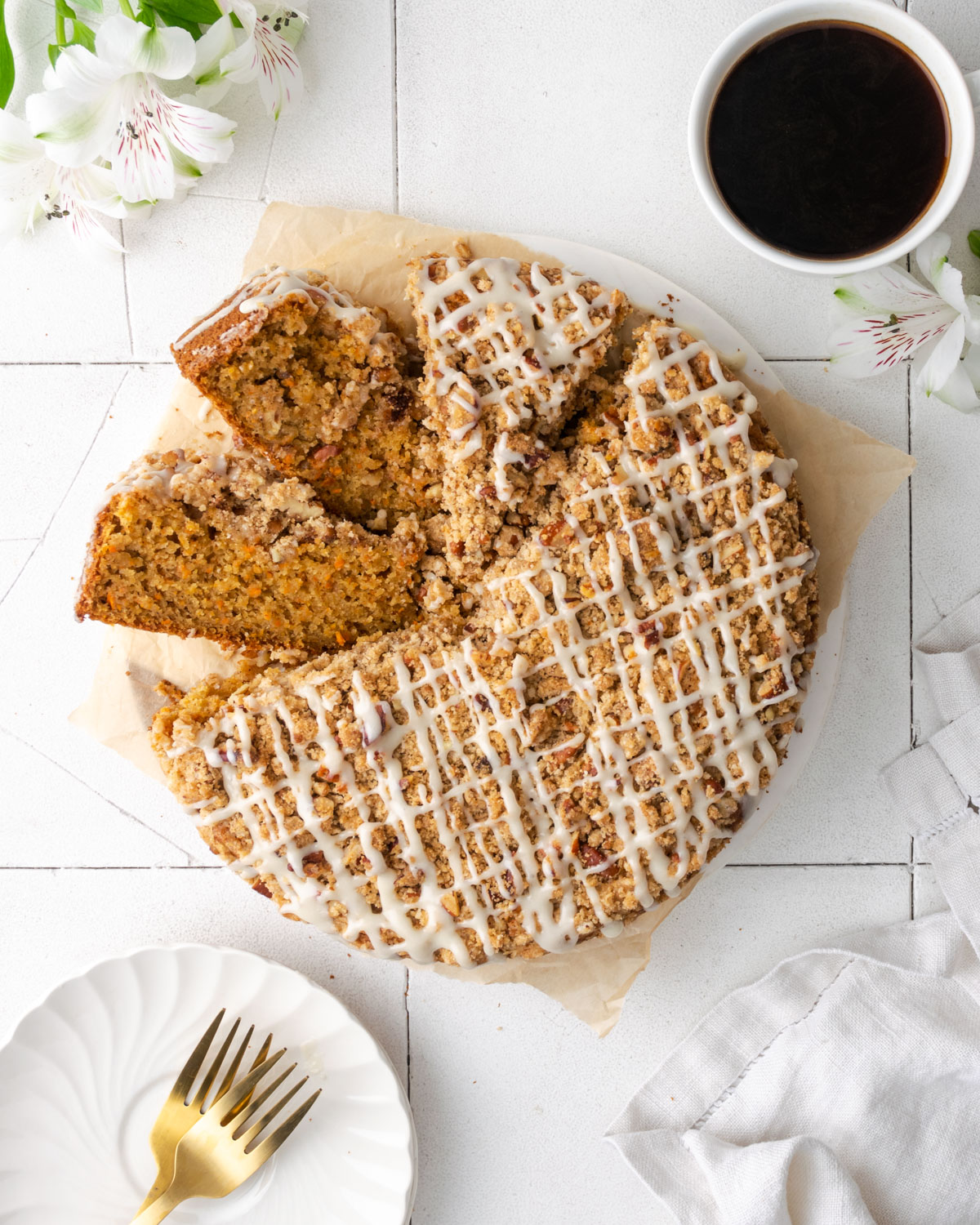 A sliced carrot cake coffee cake sitting on a tile table.