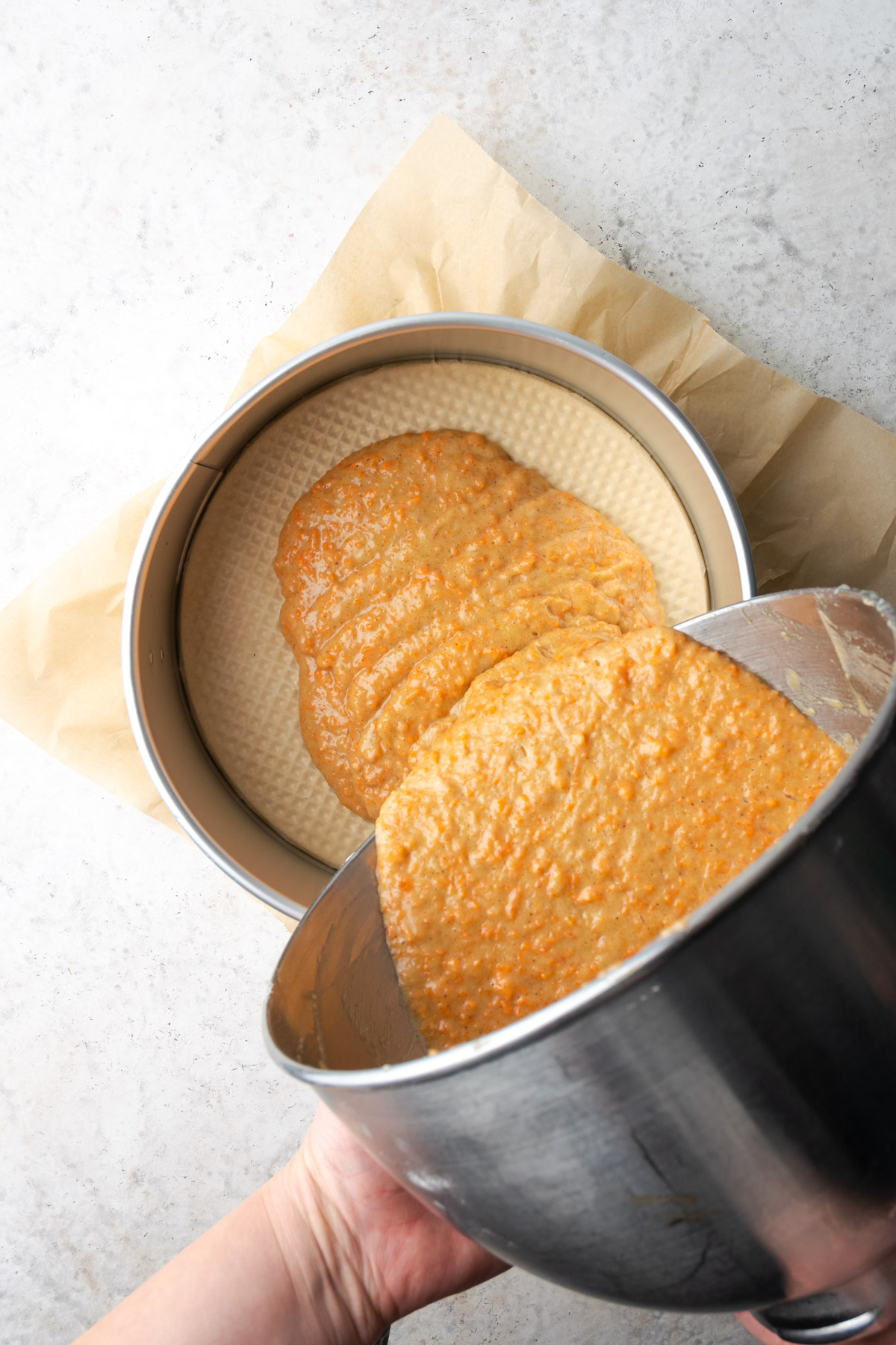 Cake batter being poured into the cake pan.