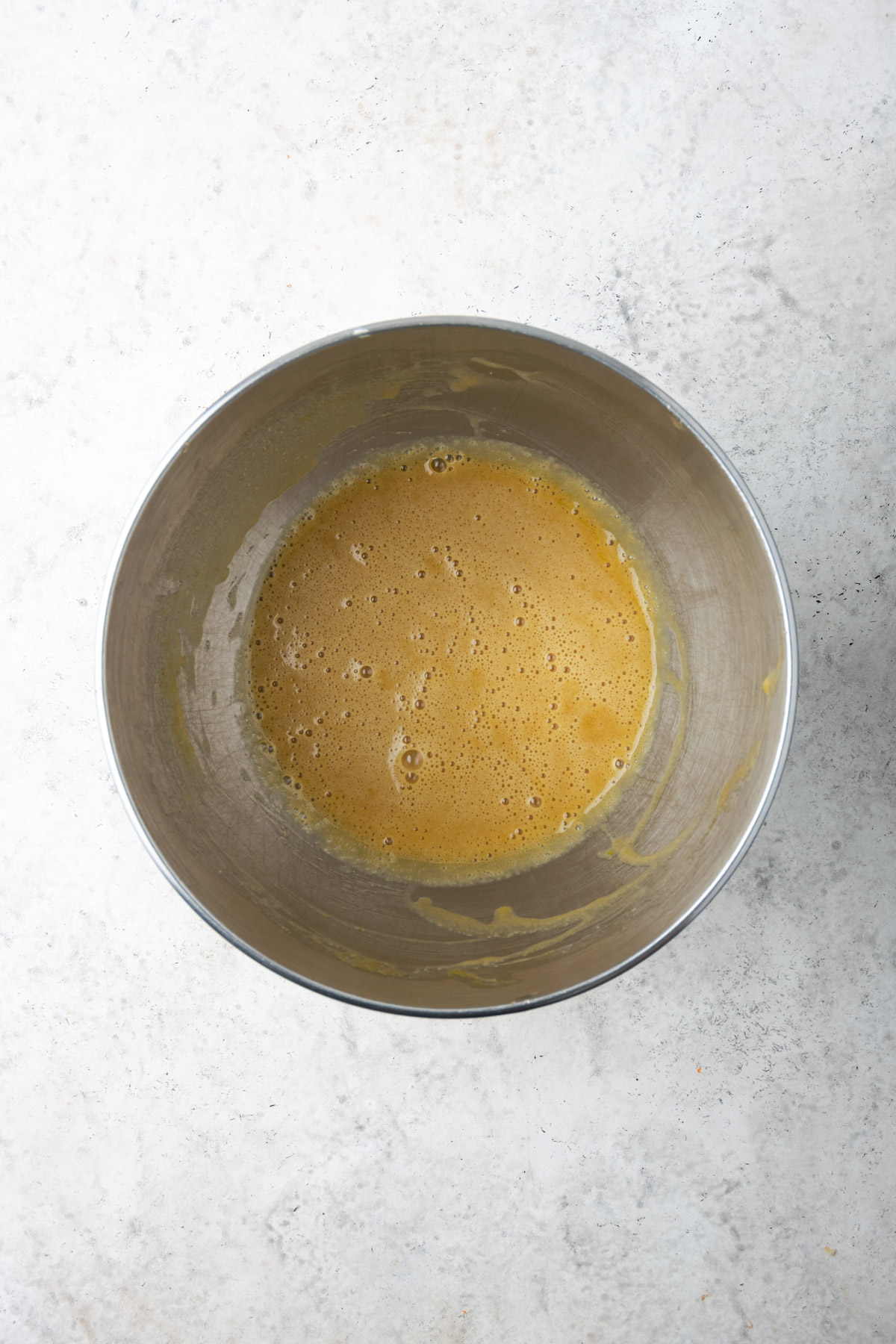 Patrially mixed cake batter in a metal bowl.