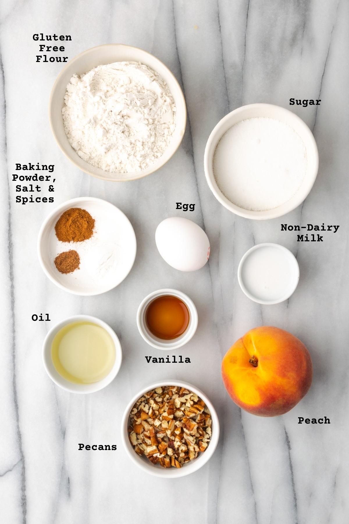 Ingredients for gluten free peach muffins on a marble counter.