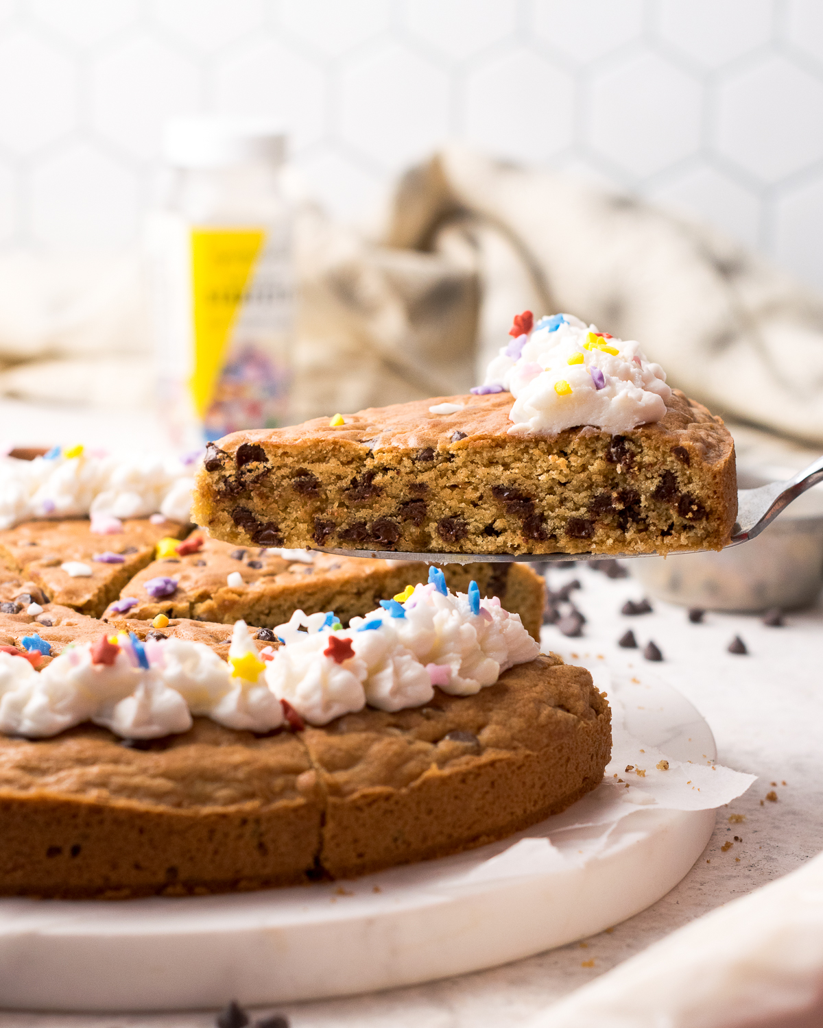 A slice of gluten free cookie cake being served.