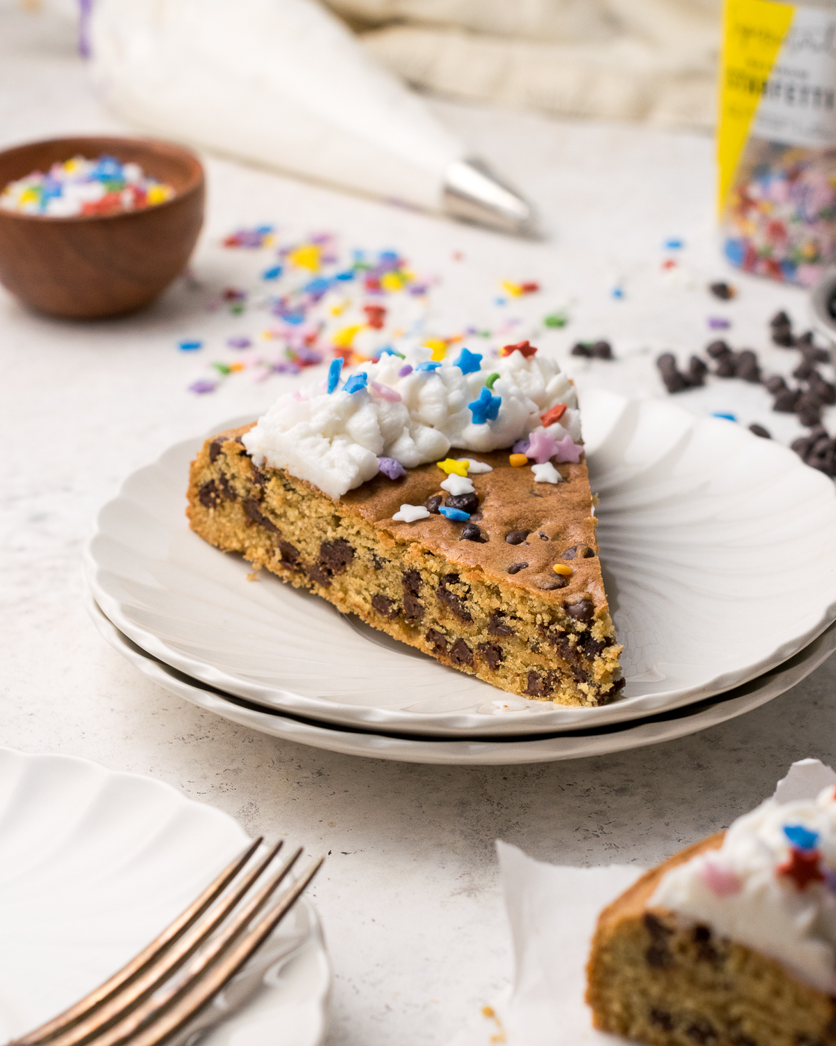 Slice of gluten free cookie cake on white plate.