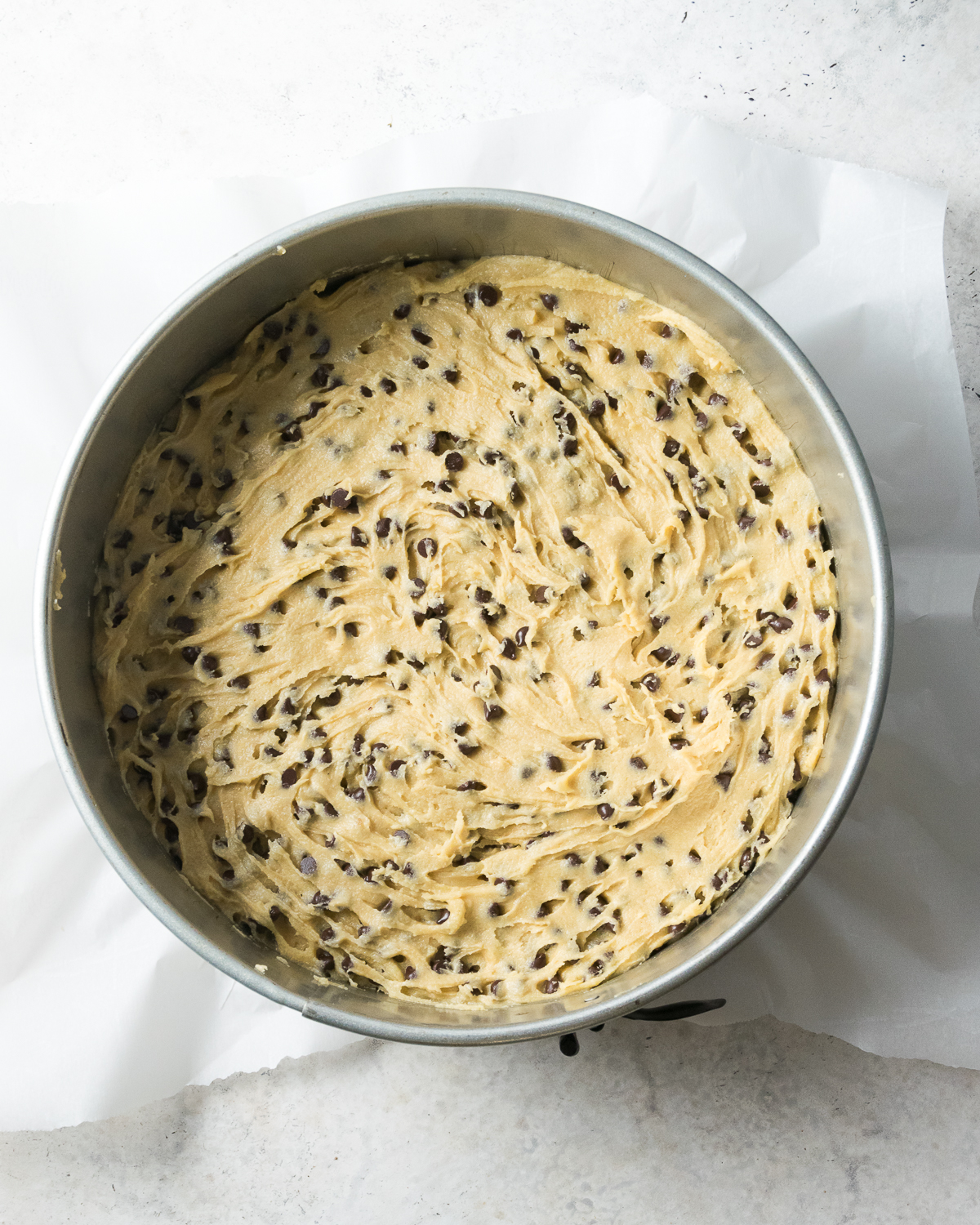 An unbaked gluten free cookie cake in a springform pan.