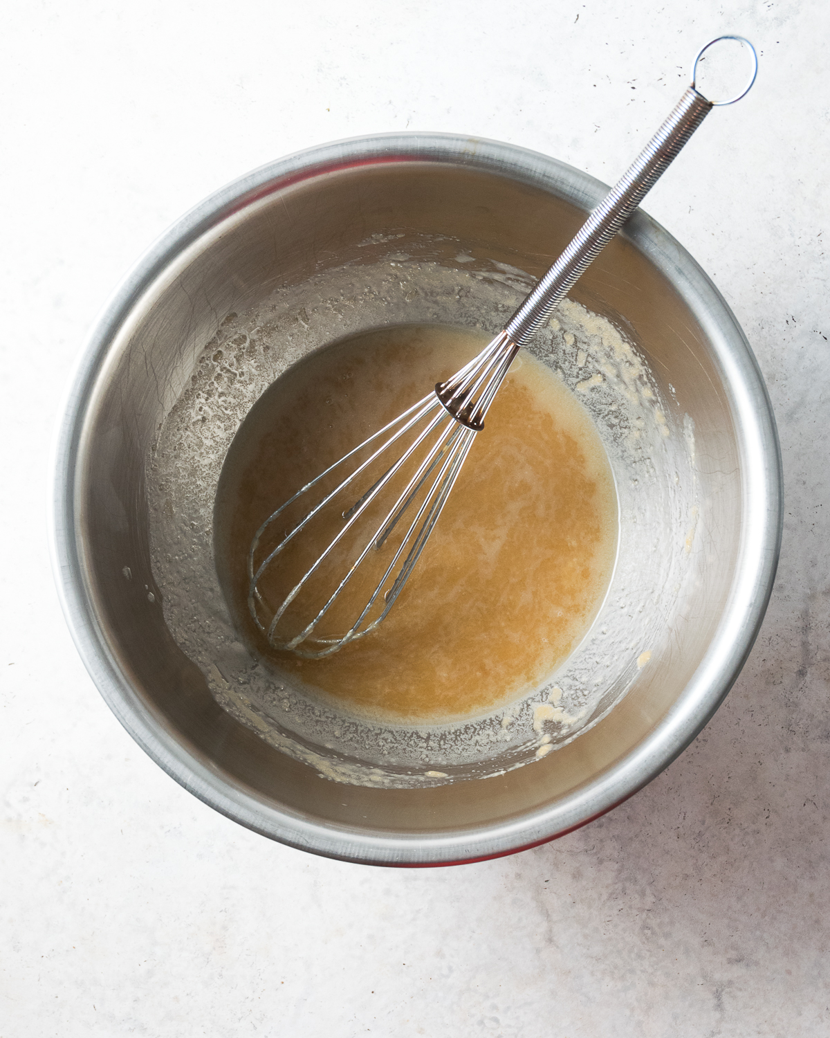 Melted butter in a large metal bowl.