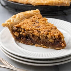 A slice of Kentucky derby pie sitting on a white plate.