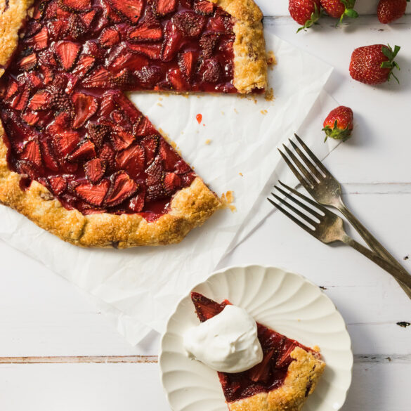 Strawberry galette with a slice served on a white plate.