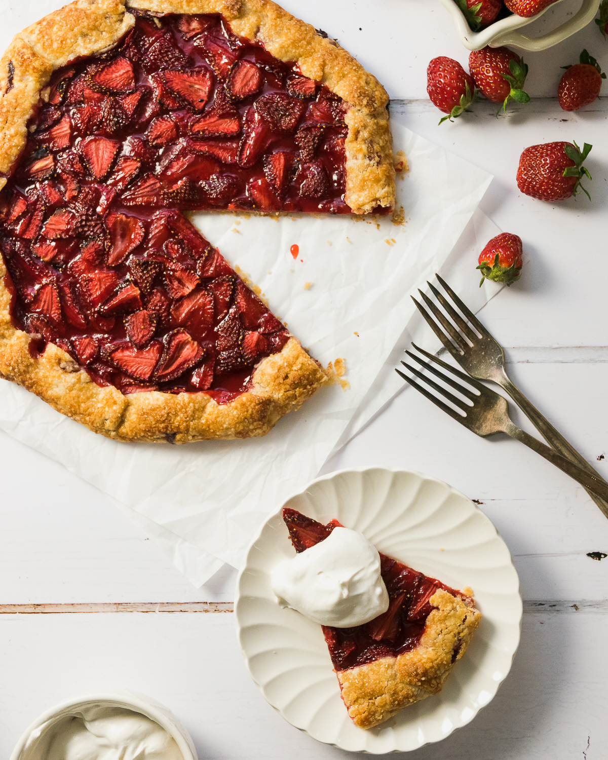 Strawberry galette with a slice served on a white plate.