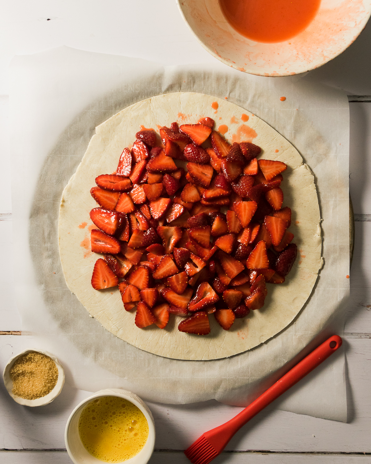 Strawberry filling piled in the center of a large circle of pie dough.