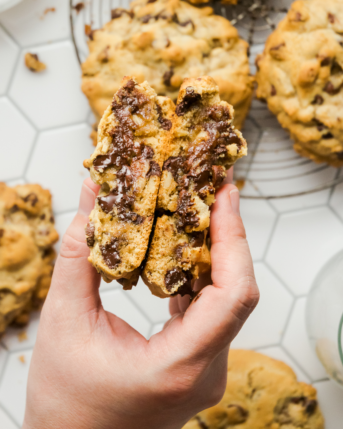 A gluten free levain cookie cut in half showing the gooey chocolate inside.