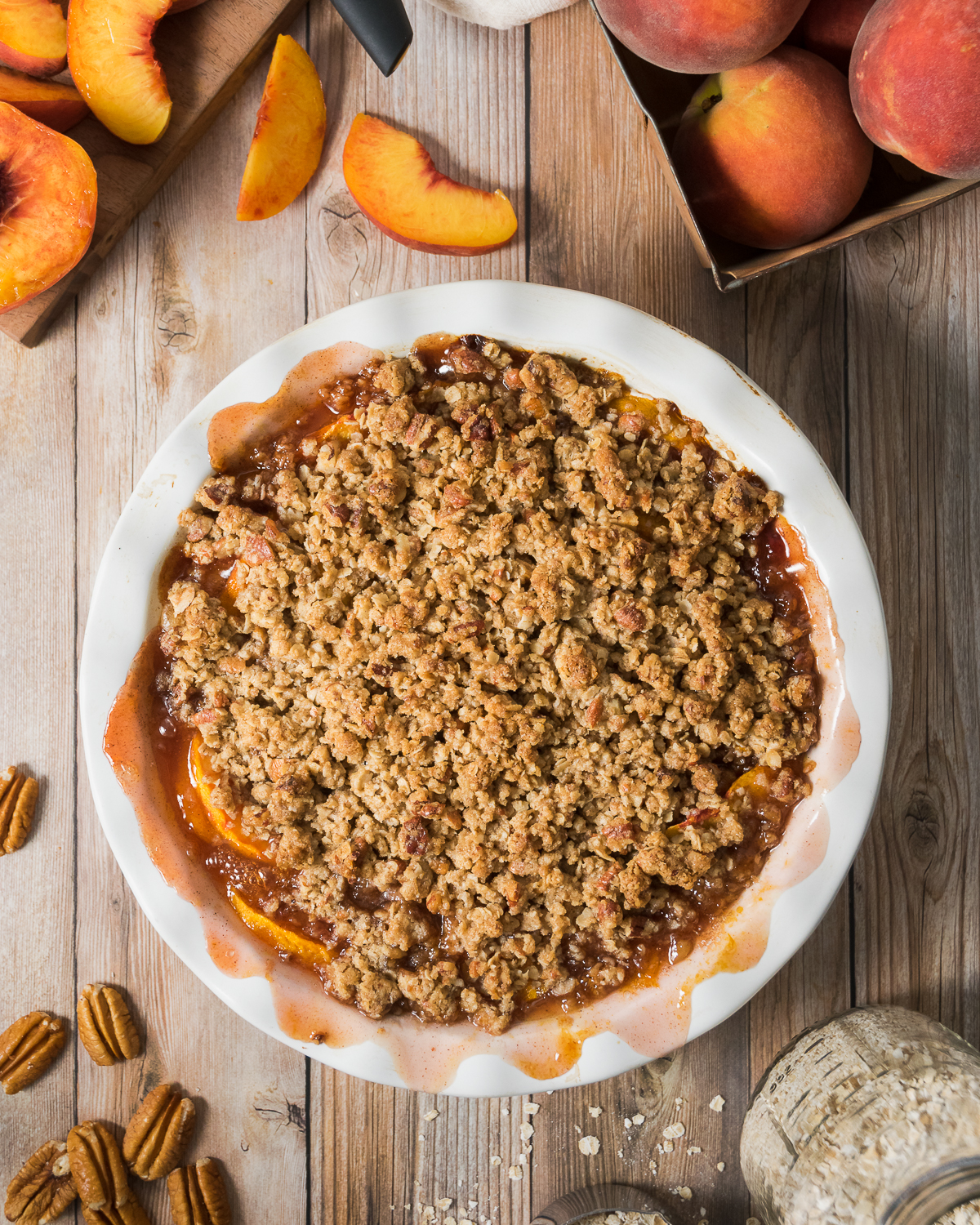 Cooked peach crisp on a wood table.
