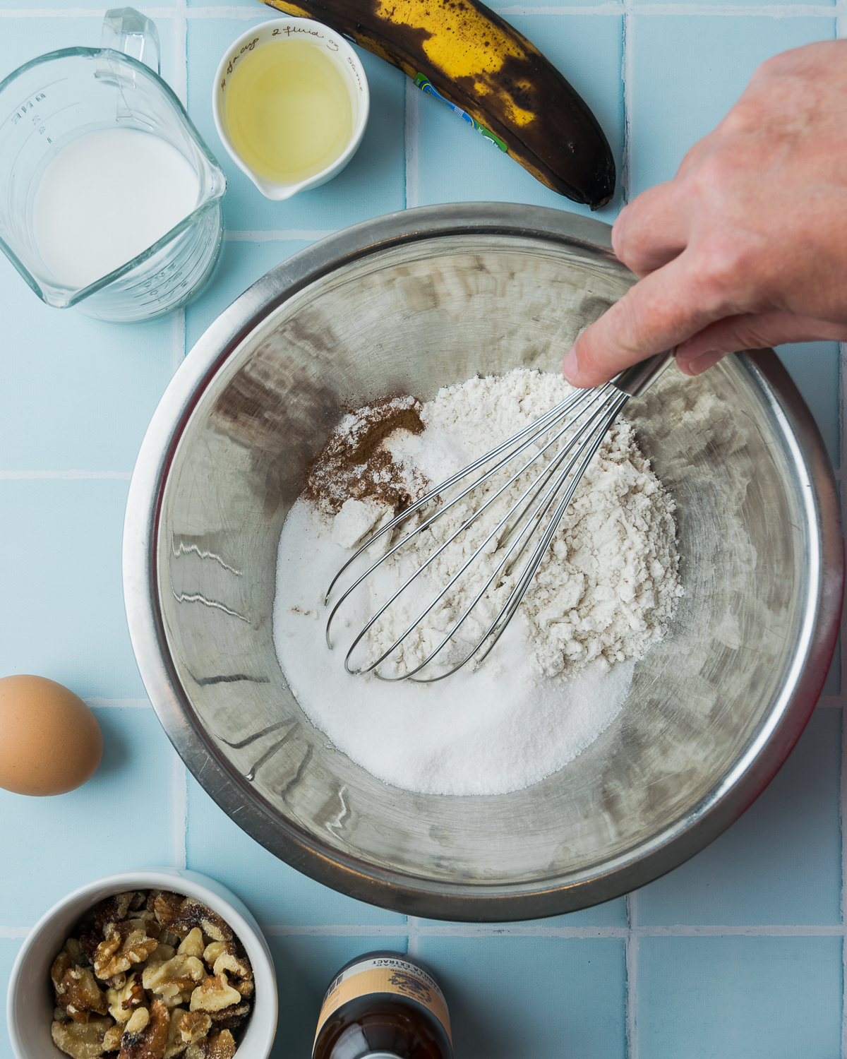 Gluten free flour, sugar, baking powder, salt and spices being whisked together in a large mixing bowl.