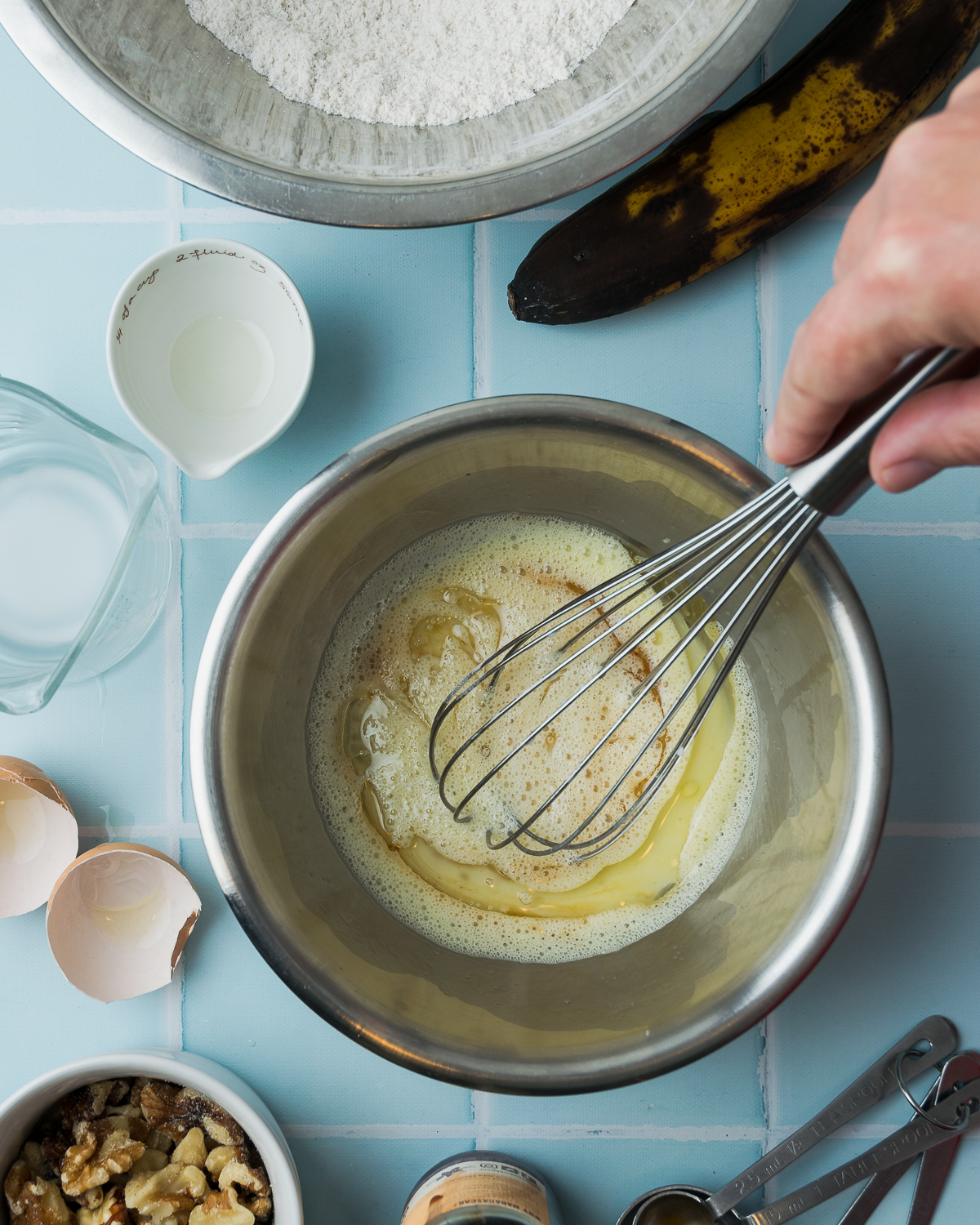 Wet ingredients being whisked together in a small mixing bowl.