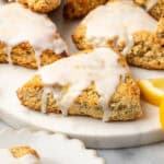Several lemon poppy seed scones sitting on a marble serving board.