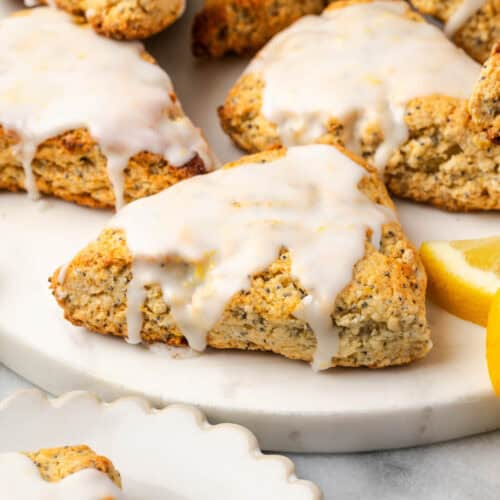 Several lemon poppy seed scones sitting on a marble serving board.