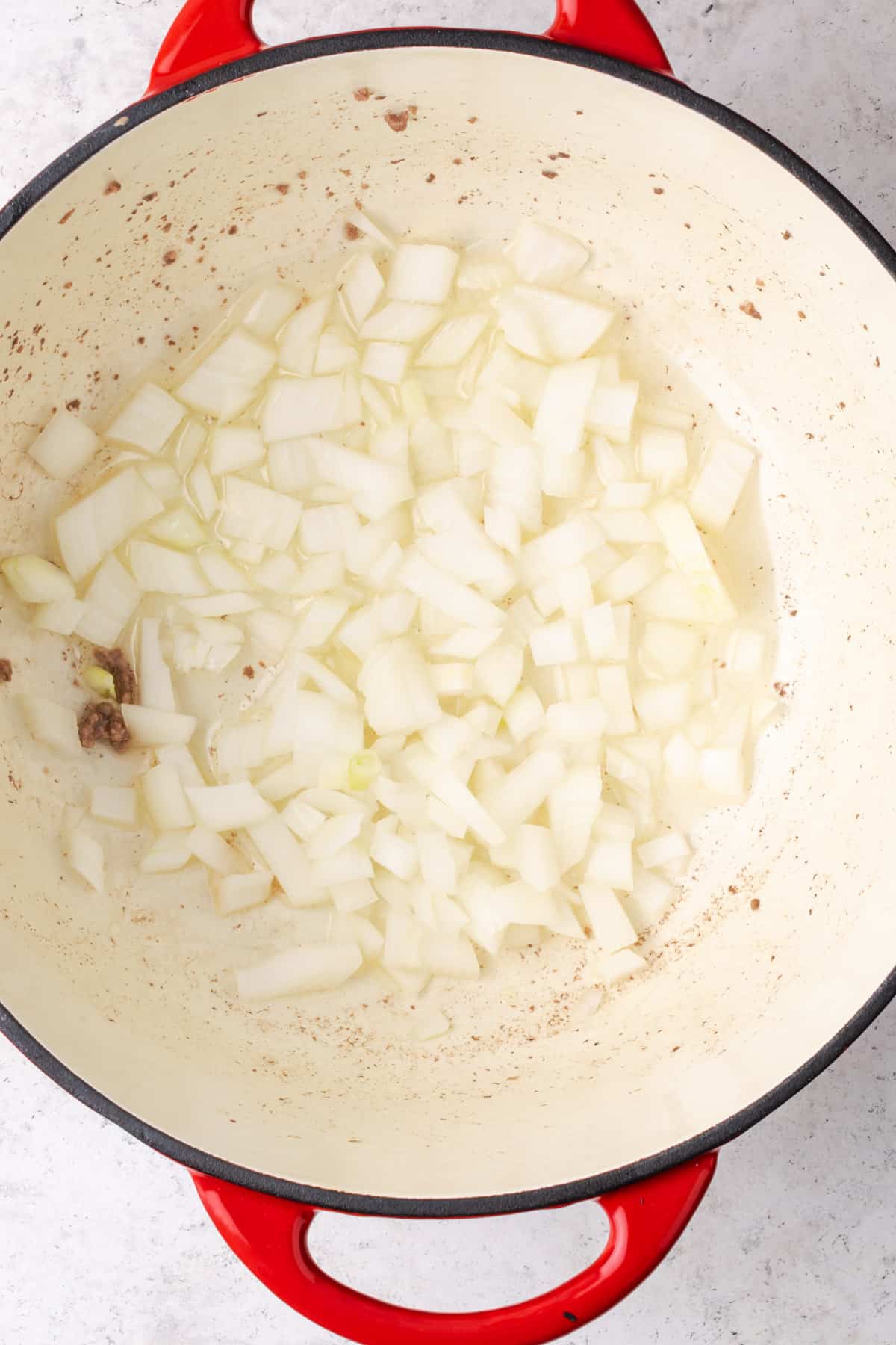 Onions cooking in a large dutch oven pot.
