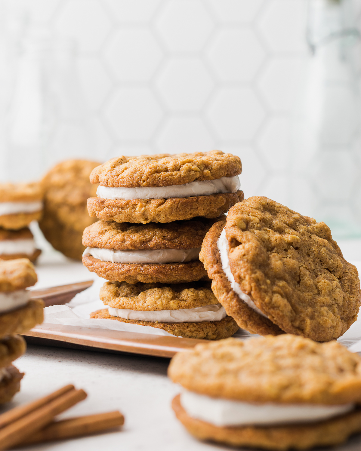 Pumpkin oatmeal cream pies stacked on a copper tray.