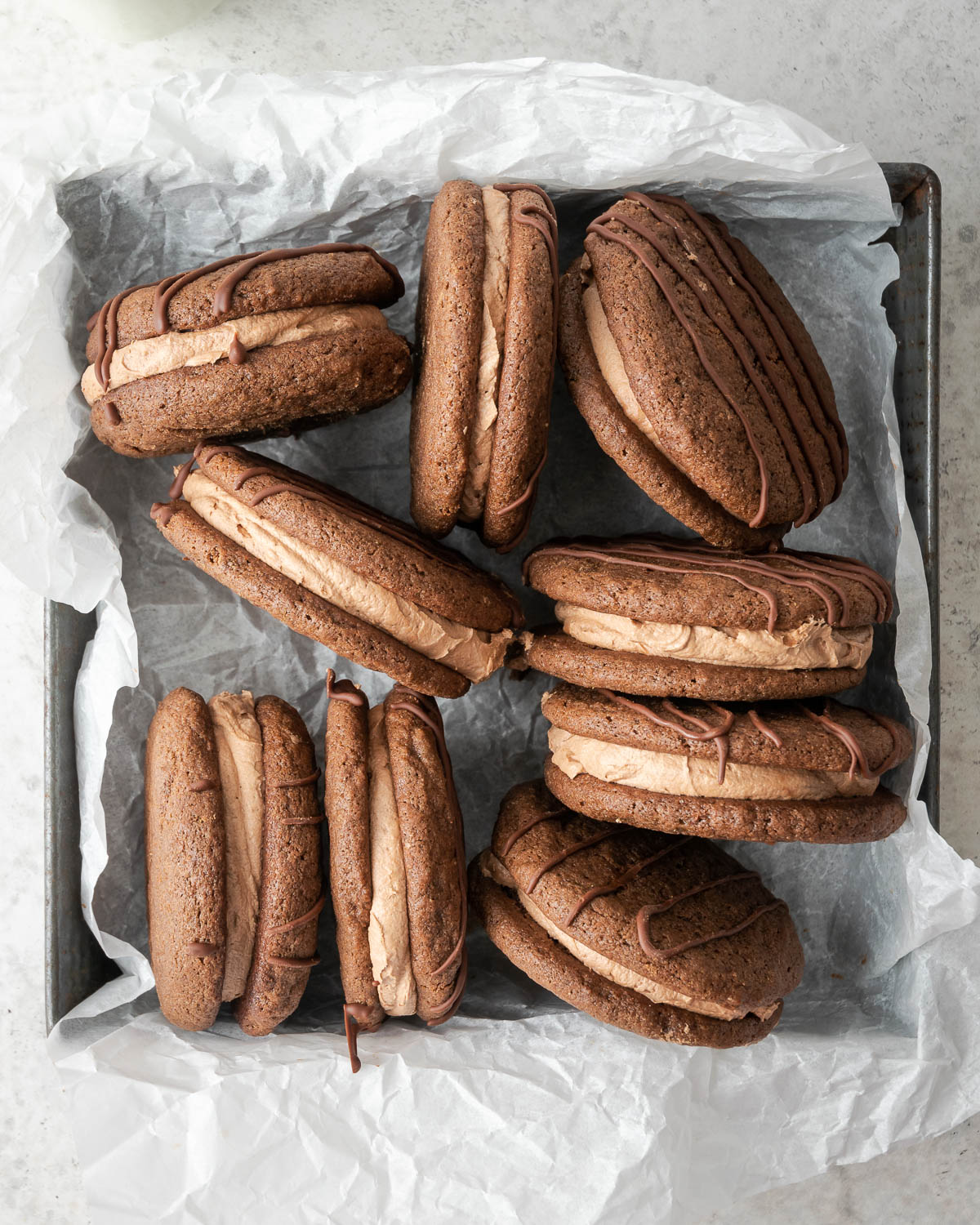 A metal tray stacked with gluten free fudge rounds.