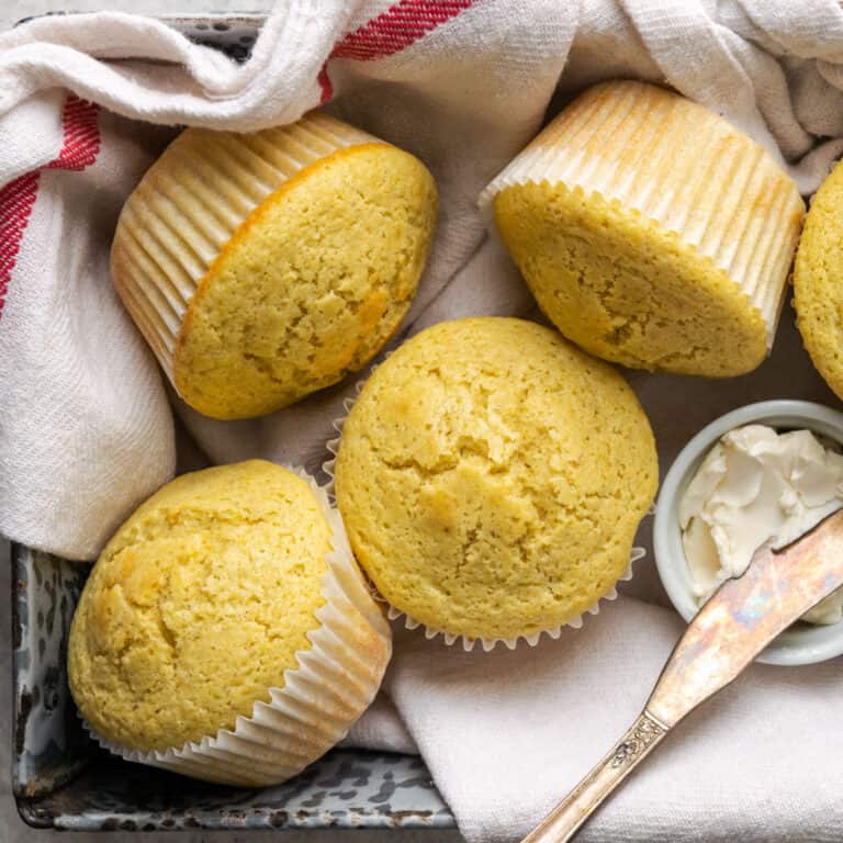 Freshly baked corn muffins served in a metal tin.