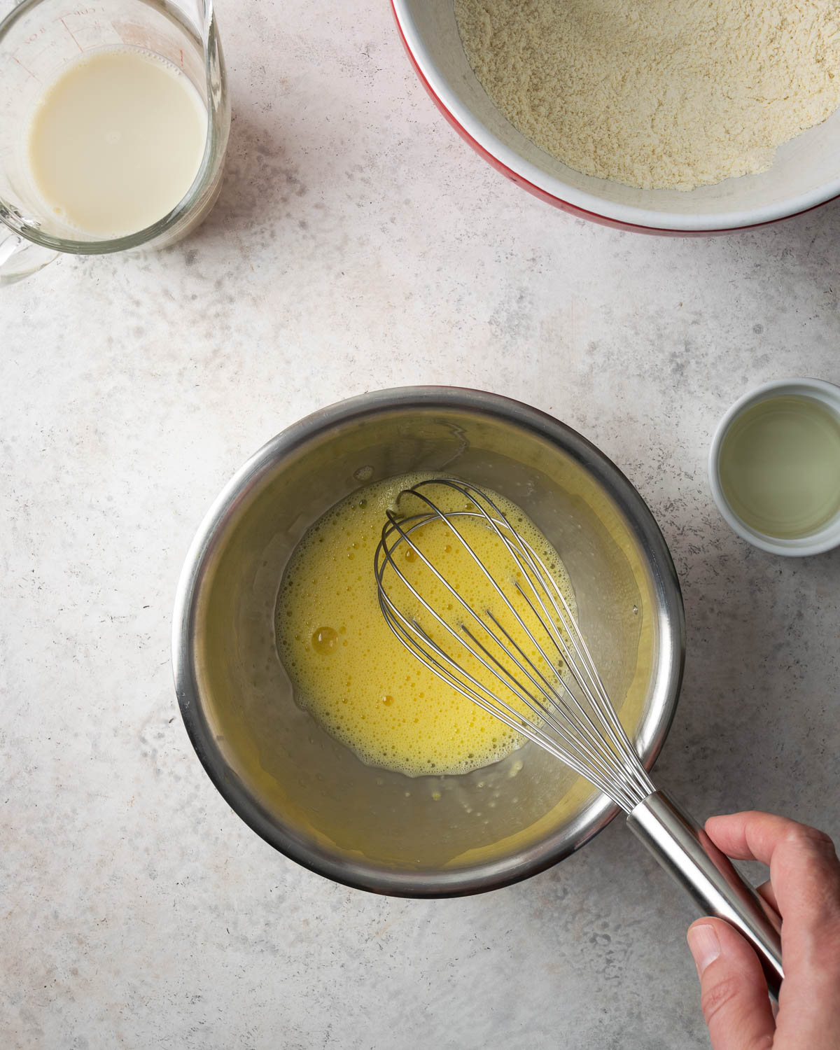 Eggs being whisked to a froth in a small bowl.