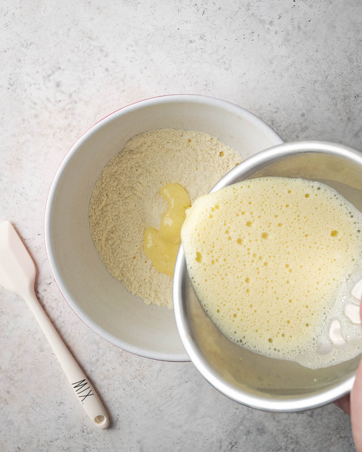 Pouring wet ingredients into dry ingredients.