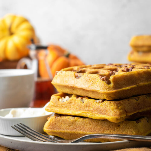 A stack of pumpkin waffles on a plate.