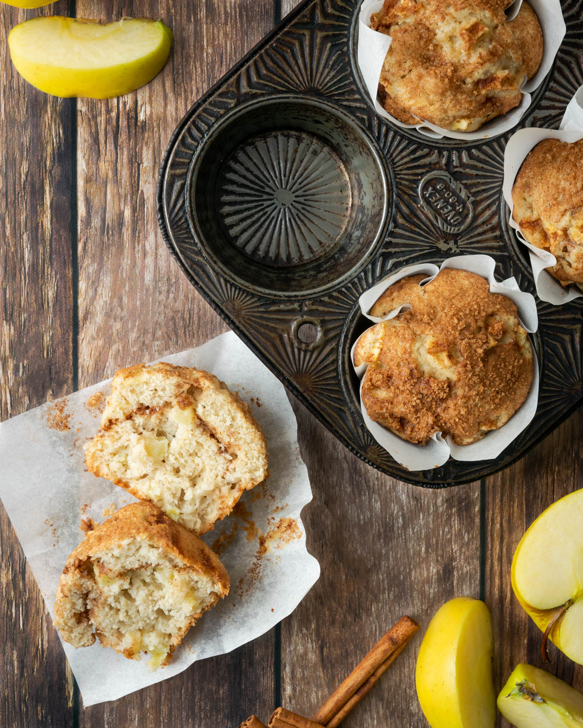 Cut open apple muffin on a wood table.