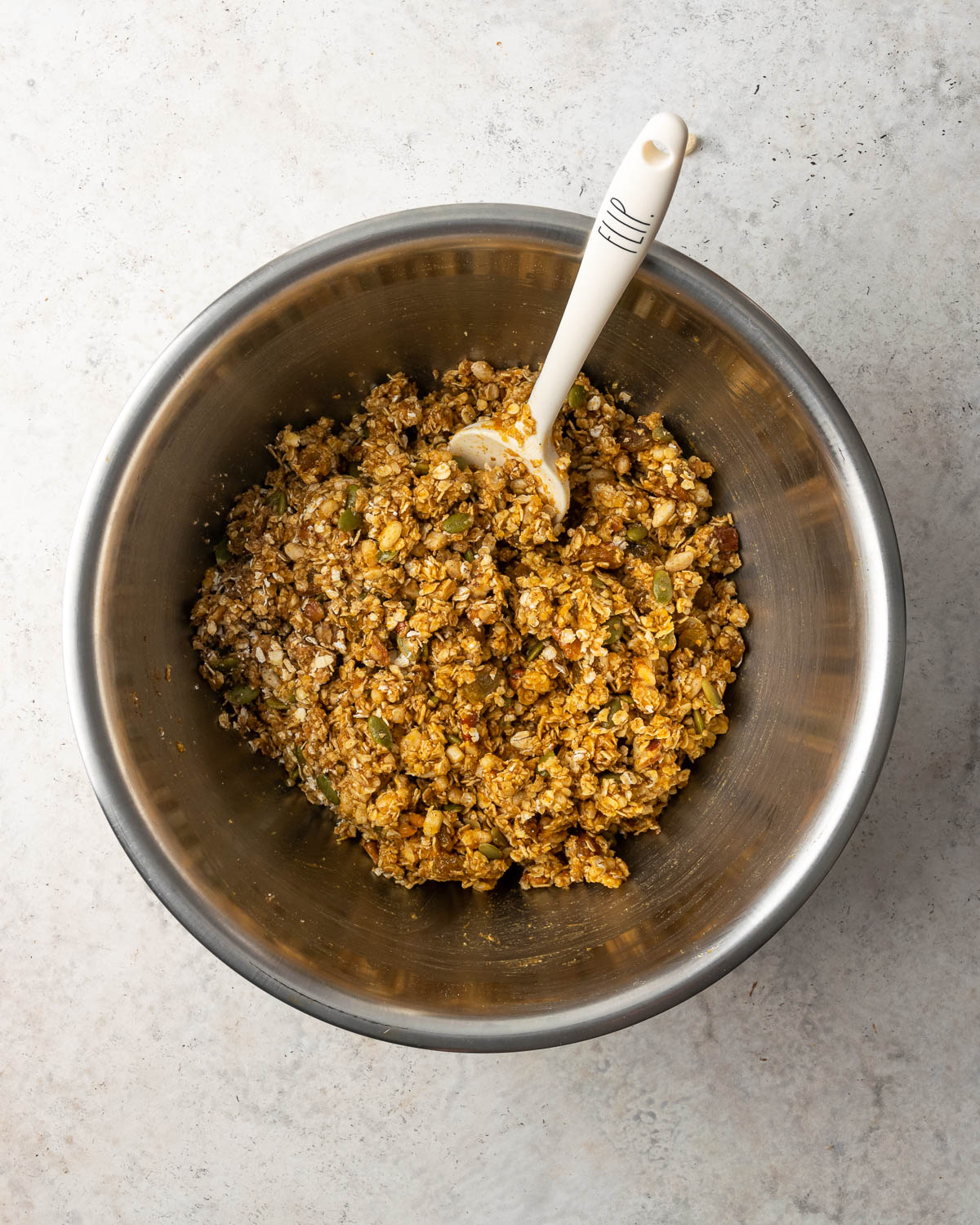 Mixed pumpkin granola in a large metal bowl.