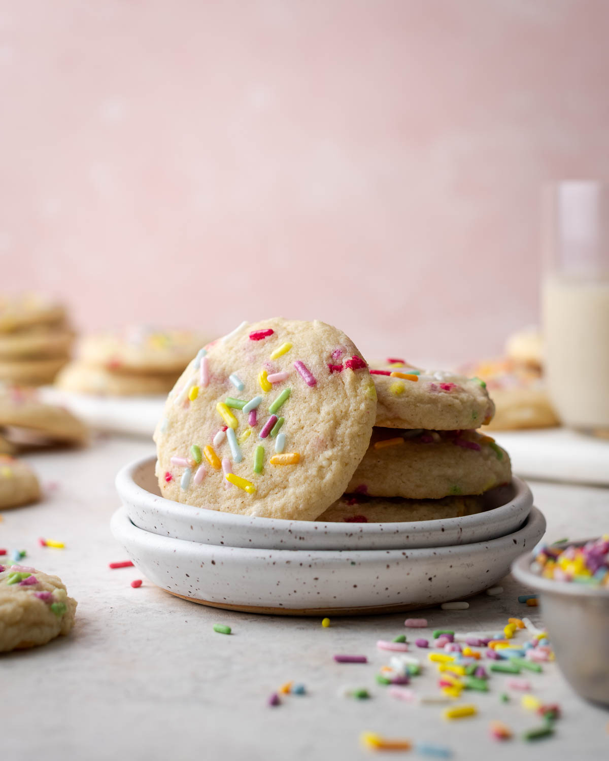 A stack of gluten free sugar cookies on a white ceramic plate.