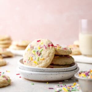 A stack of gluten free sugar cookies on a white plate.