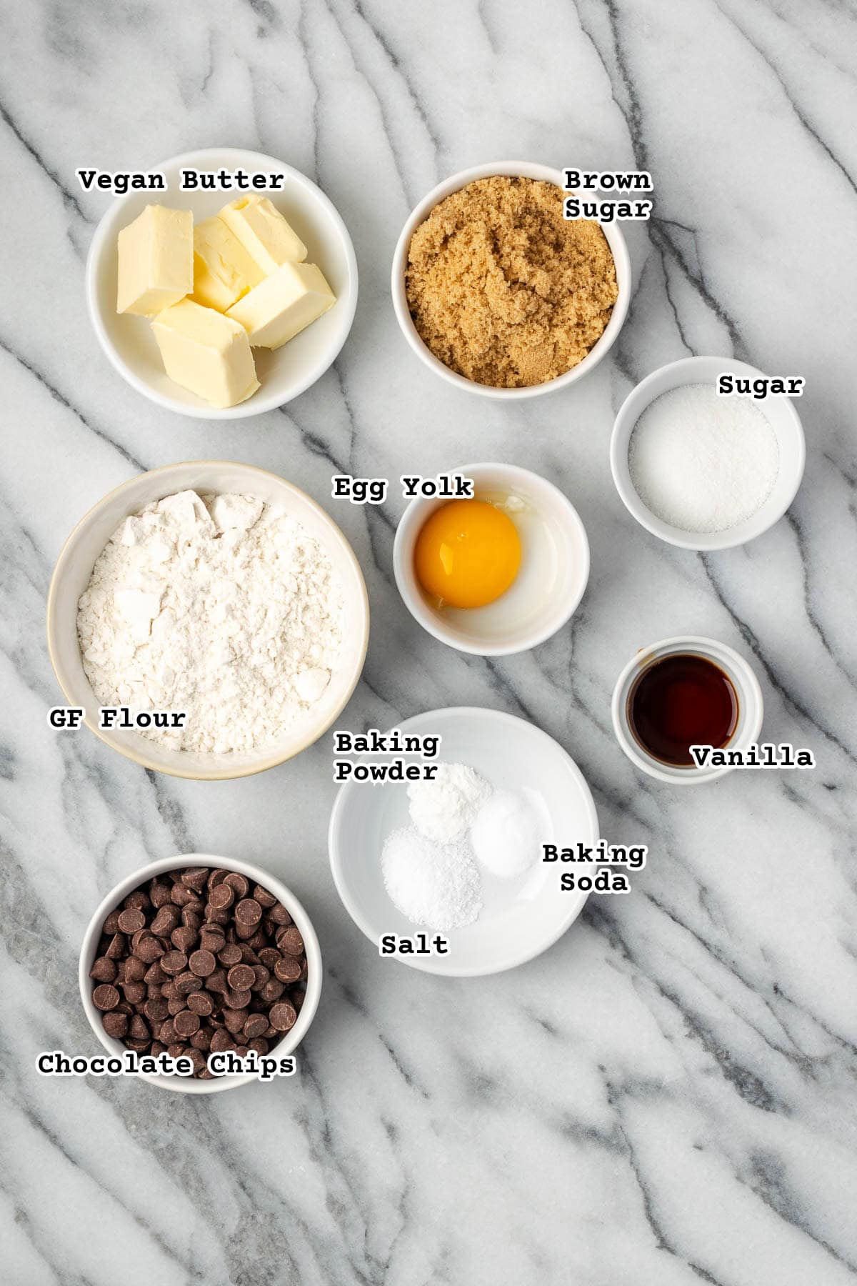 Ingredients for gluten free chocolate chip cookies sitting on a marble counter.