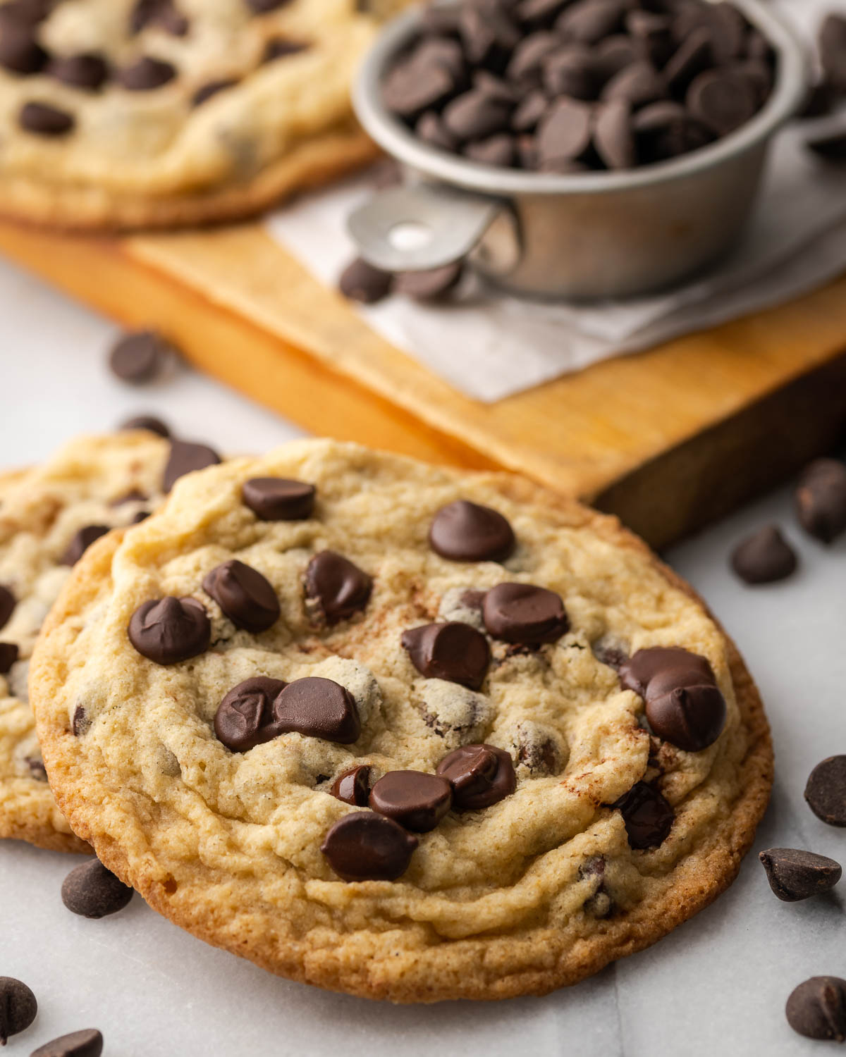 A closeup of a chocolate chip cookie loaded with chocolate chips and wrinkly texture.
