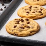 Several gluten free chocolate chip cookies sitting on a baking sheet.