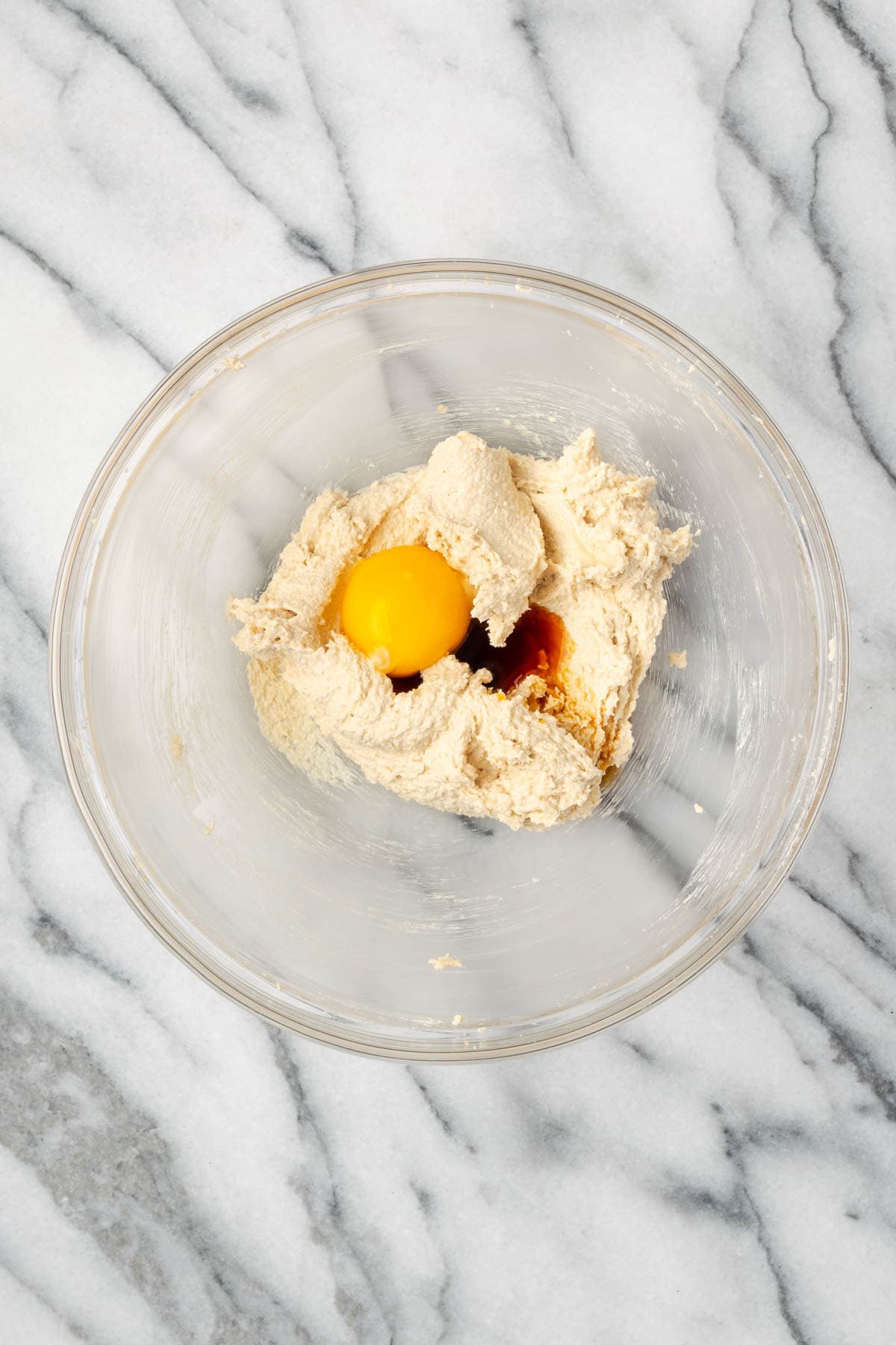 Egg yolk and vanilla extract added to the bowl with the creamed butter and sugars.