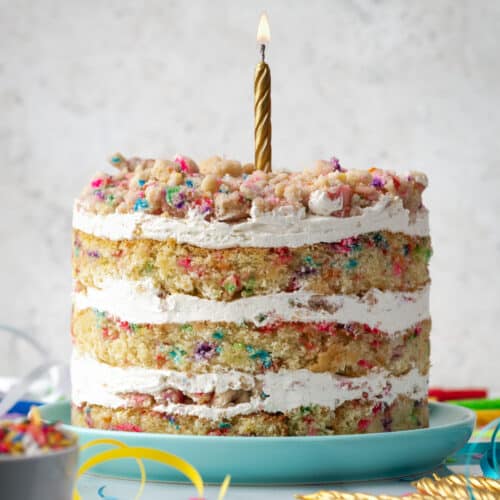 A milk bar birthday cake topped with a single gold candle.