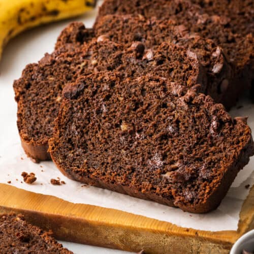 A closeup of slices of chocolate banana bread on a cutting board.