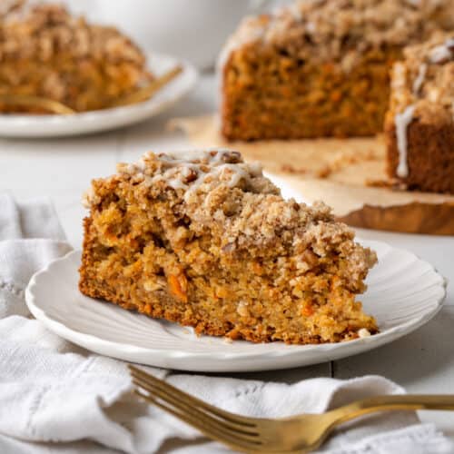 A slice of carrot coffee cake on a white plate.