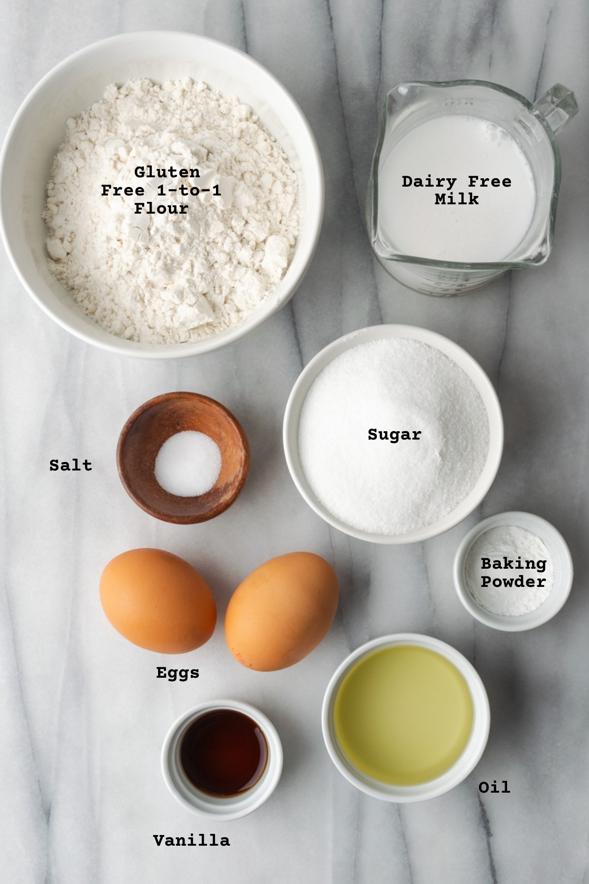 Ingredients for vanilla gluten free cupcakes on a marble table.