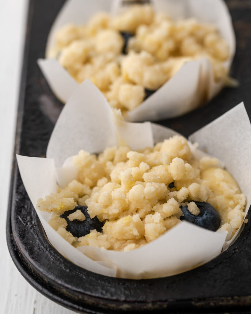 Lemon crumble topping on unbaked muffin batter.
