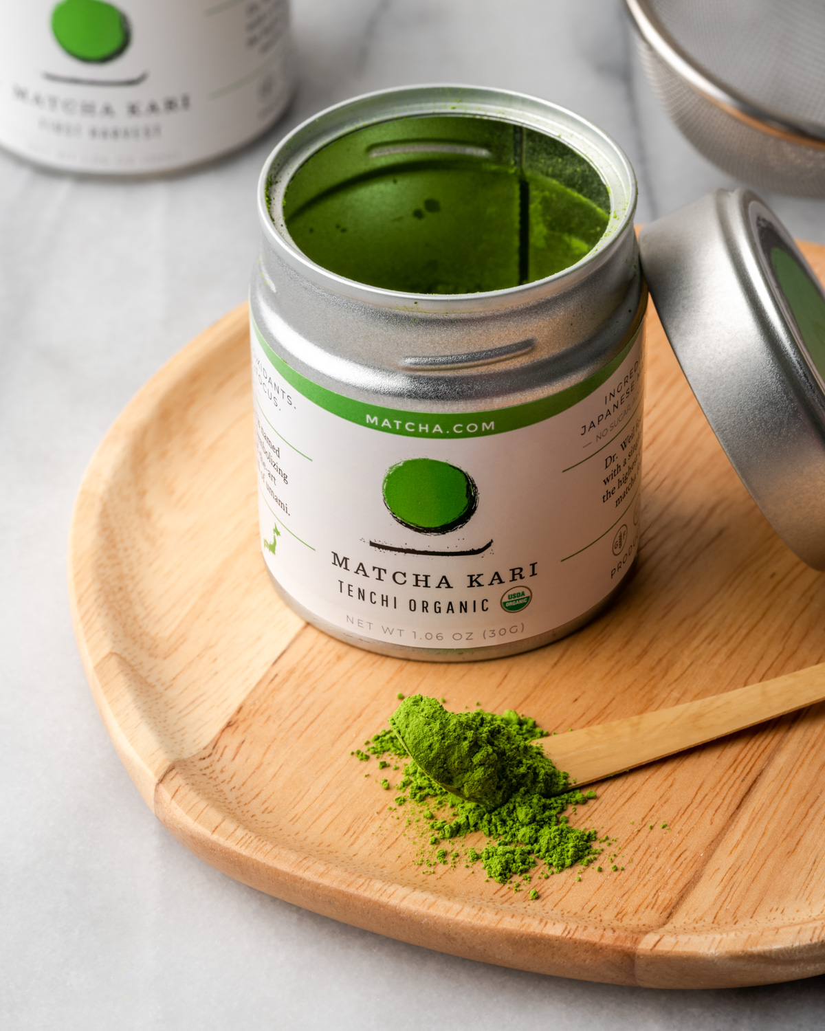 A can of matcha green tea powder on a wooden plate.