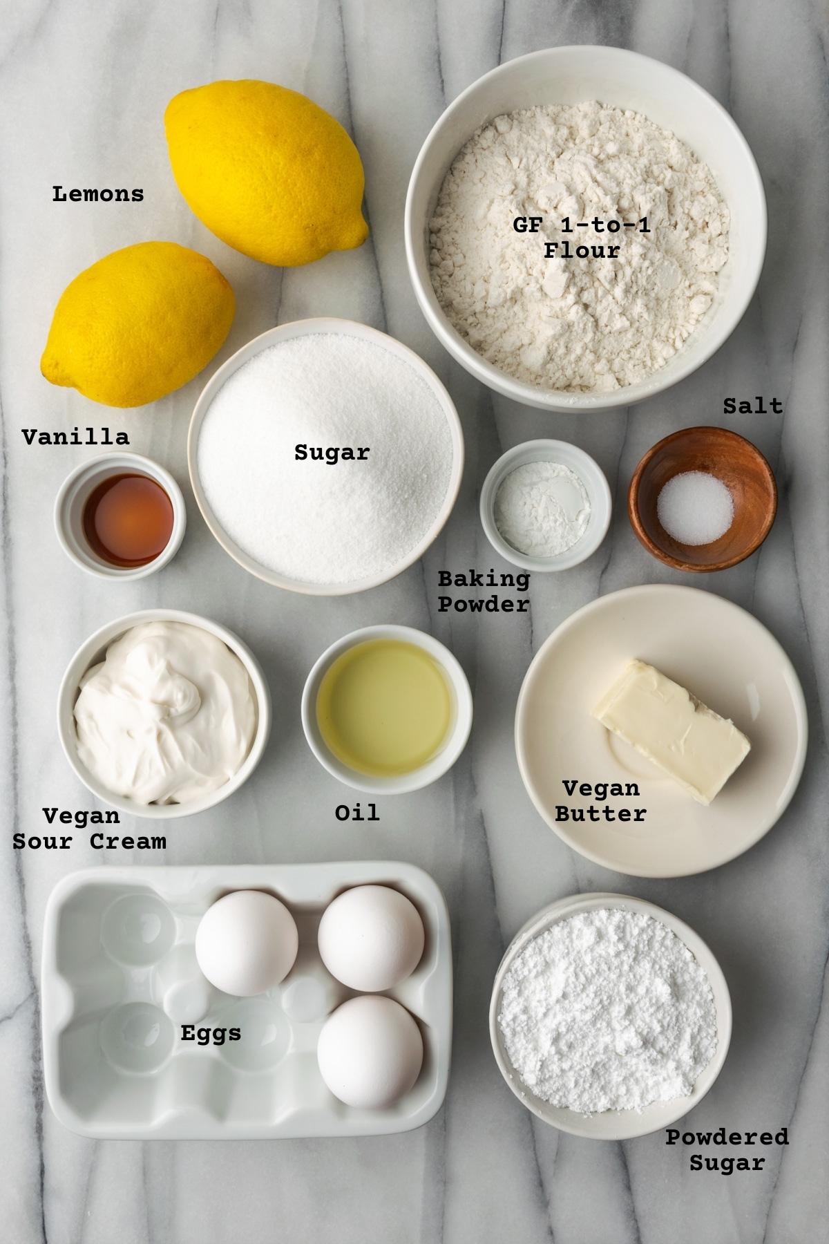 Ingredients for gluten free lemon loaf cake on a marble table.